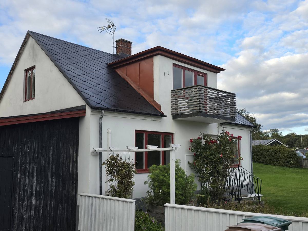 Nybehandlat svart tak på vitt hus
